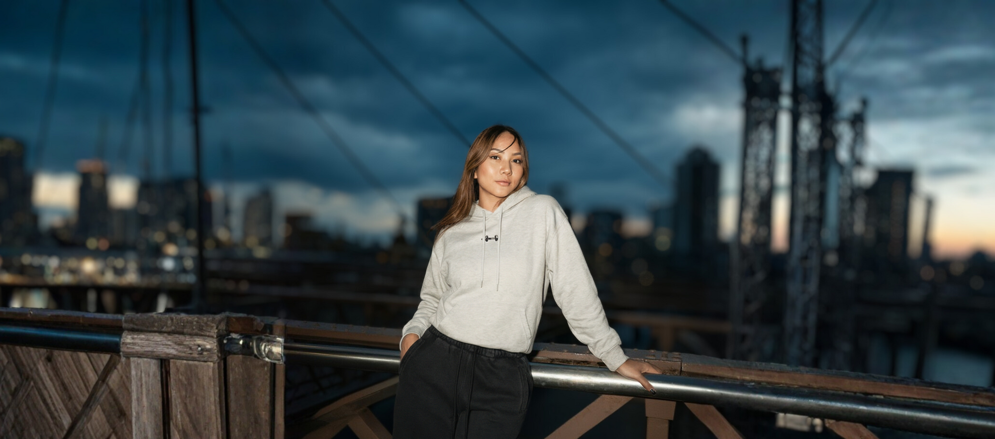 Person standing on a bridge with a cityscape in the background
